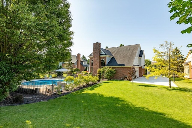 view of yard with fence, a patio area, and a fenced in pool