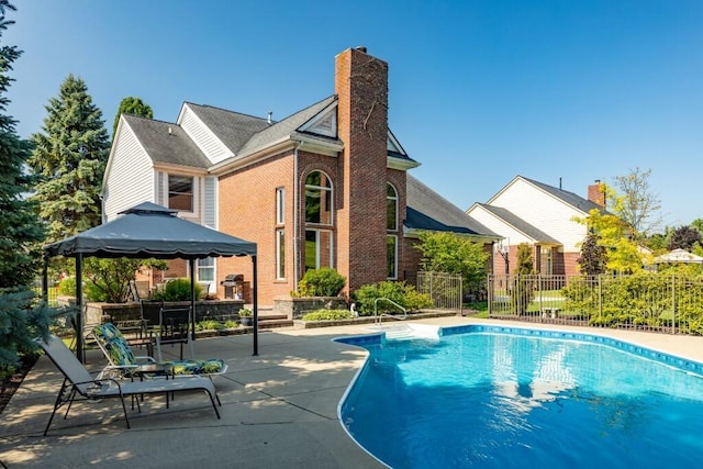 view of swimming pool with a gazebo, a fenced in pool, a patio area, and fence