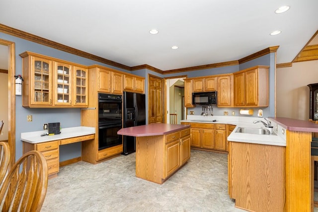 kitchen with black appliances, ornamental molding, a sink, a center island, and glass insert cabinets