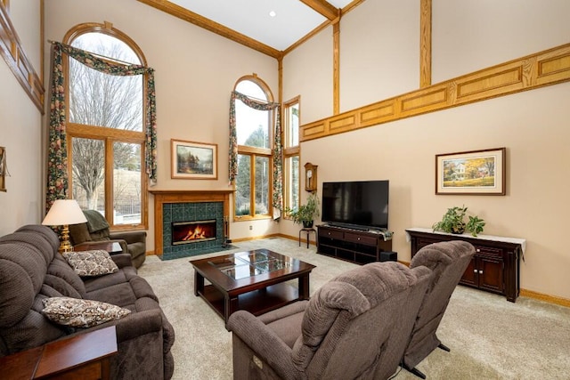 living room with light carpet, crown molding, baseboards, a towering ceiling, and a tile fireplace