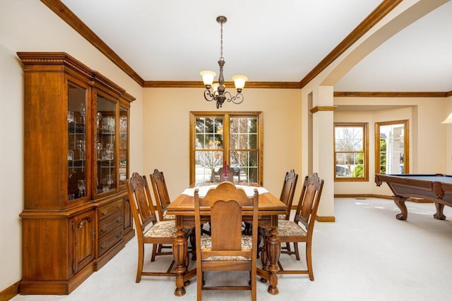 dining area featuring crown molding, baseboards, a chandelier, and light carpet