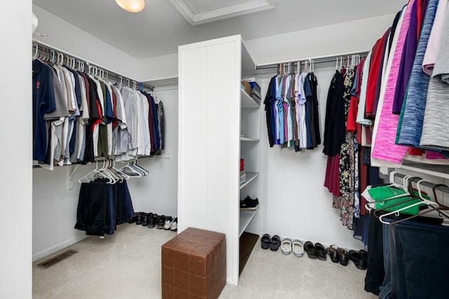 spacious closet with visible vents, attic access, and carpet