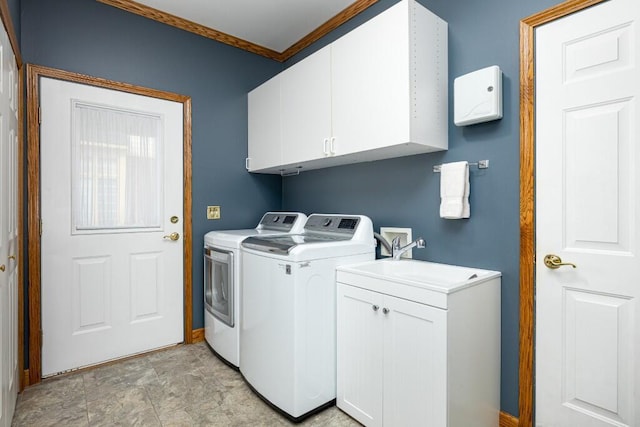 clothes washing area featuring baseboards, cabinet space, a sink, crown molding, and washer and clothes dryer