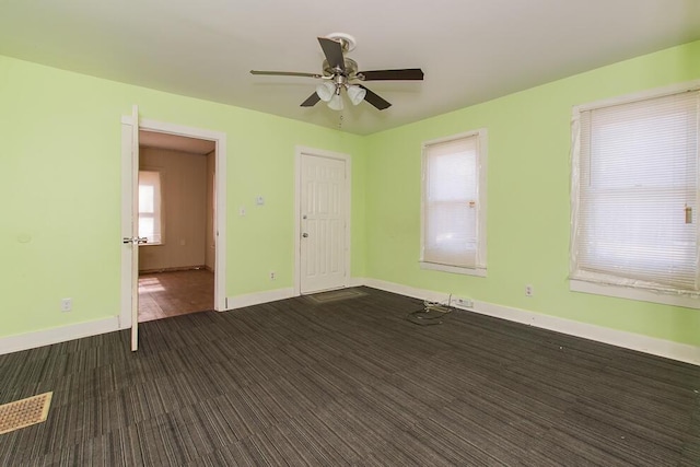 unfurnished room featuring a ceiling fan and baseboards