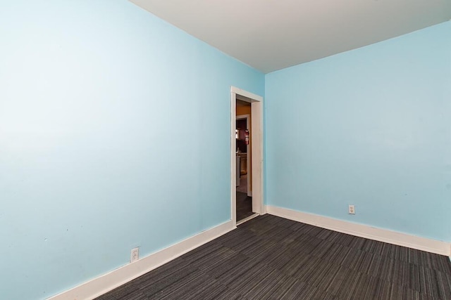 unfurnished room with baseboards