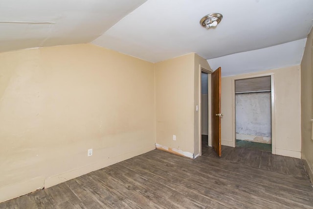 unfurnished bedroom with vaulted ceiling and wood finished floors