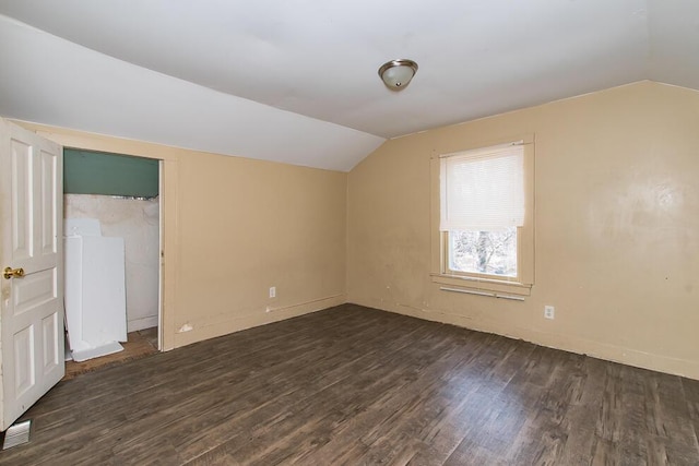 additional living space featuring visible vents, lofted ceiling, baseboards, and wood finished floors