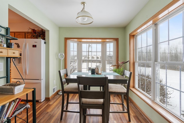 dining space featuring visible vents, baseboards, and wood finished floors