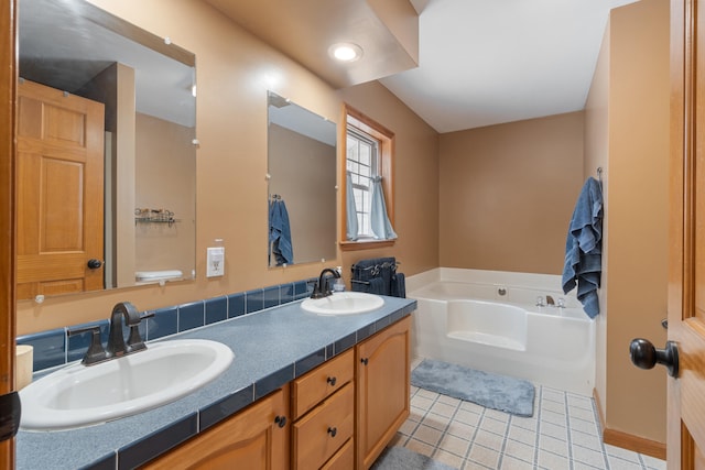 full bathroom featuring tile patterned flooring, a garden tub, double vanity, and a sink