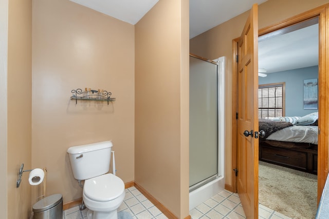 ensuite bathroom with connected bathroom, baseboards, toilet, and a stall shower