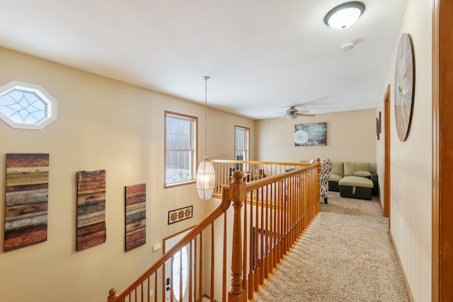 hall featuring an upstairs landing, light colored carpet, and a chandelier