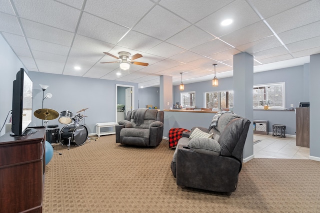 carpeted living room featuring ceiling fan, a paneled ceiling, and baseboards