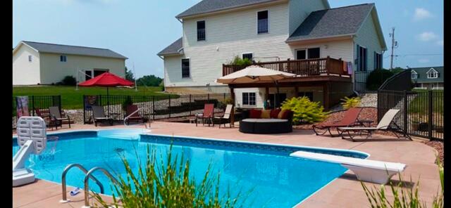 rear view of house with a fenced in pool, fence, and a patio area