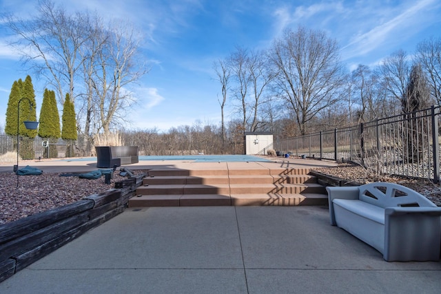 view of patio with a community pool, a storage shed, an outdoor structure, and fence