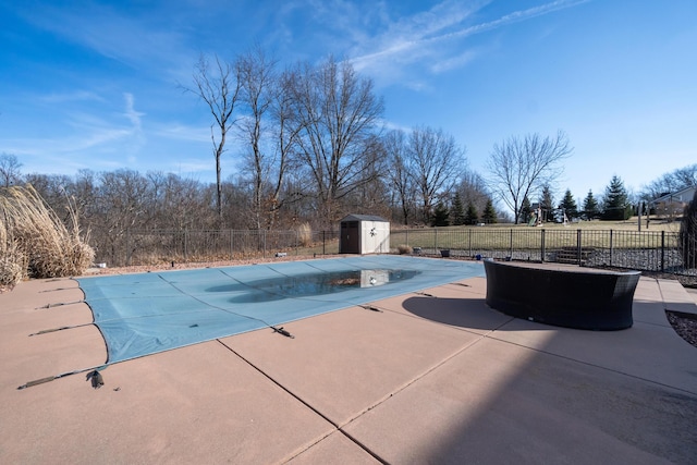 view of swimming pool with a fenced backyard, a storage shed, an outdoor structure, a fenced in pool, and a patio area