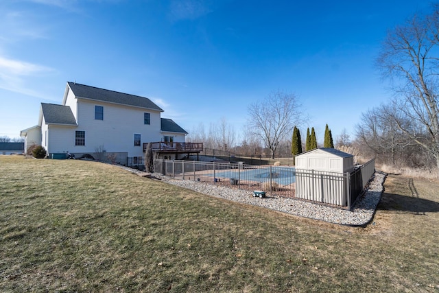 view of yard featuring a storage unit, a deck, fence, an outdoor structure, and a fenced in pool