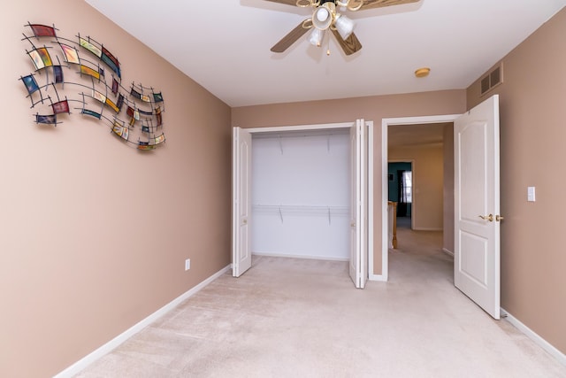 unfurnished bedroom with visible vents, light carpet, a closet, baseboards, and ceiling fan