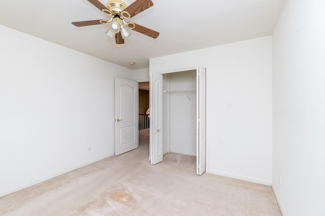 unfurnished bedroom featuring light carpet, ceiling fan, a closet, and baseboards