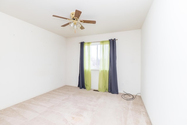 spare room with visible vents, light carpet, and ceiling fan