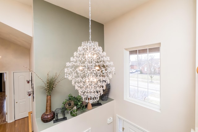 interior details with wood finished floors and a chandelier