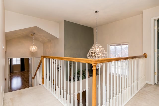 hallway featuring an upstairs landing and a notable chandelier