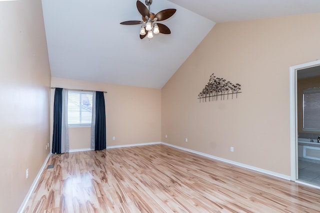 spare room with vaulted ceiling, light wood-style flooring, baseboards, and ceiling fan