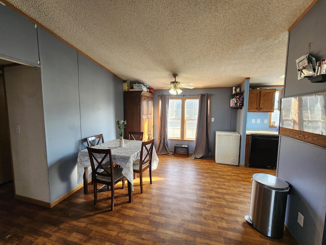 dining area featuring baseboards, dark wood-type flooring, a ceiling fan, and a textured ceiling