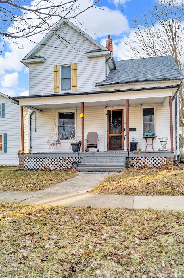 view of front of home featuring a porch and a chimney