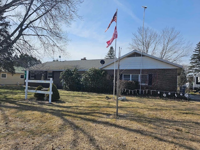 exterior space with a front lawn and brick siding