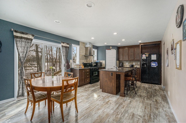 dining area with recessed lighting, light wood-style floors, baseboards, and a textured ceiling