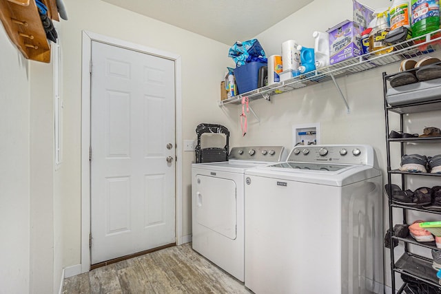 laundry area with light wood-type flooring, laundry area, and washer and clothes dryer