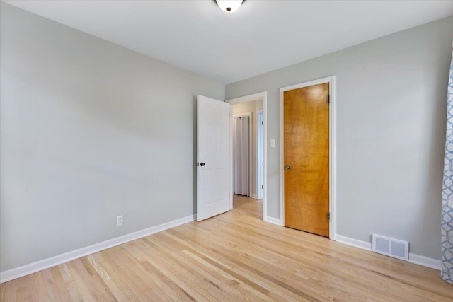 spare room featuring visible vents, baseboards, and light wood-style floors