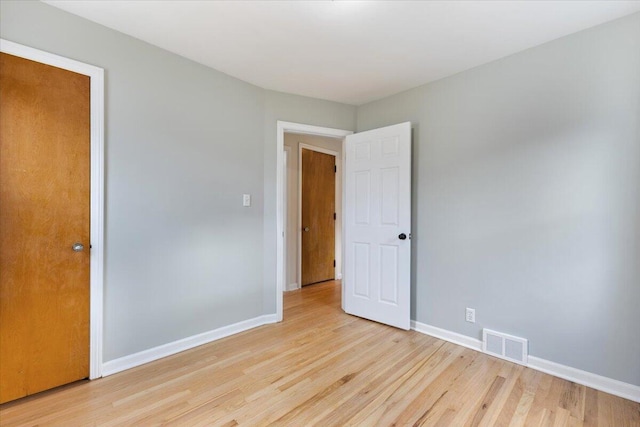 unfurnished room featuring light wood-style flooring, baseboards, and visible vents