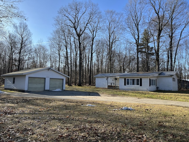 exterior space with an outdoor structure, a garage, and metal roof