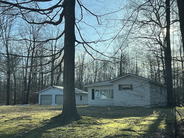 view of front of home featuring a detached garage and an outdoor structure