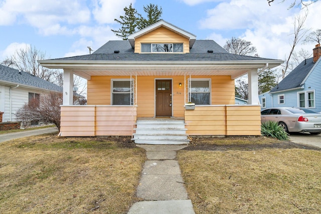 bungalow with a porch and roof with shingles