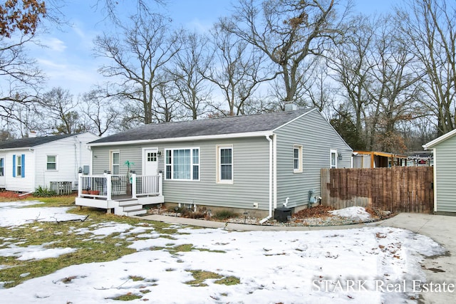 bungalow-style house with cooling unit, fence, and a wooden deck