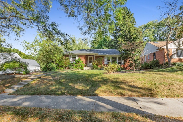 ranch-style home featuring brick siding and a front yard