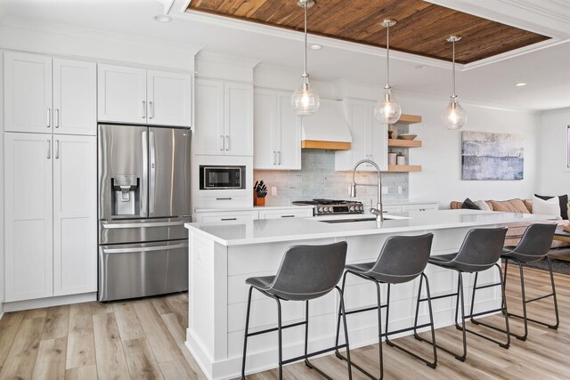 kitchen with wood ceiling, a tray ceiling, black microwave, and stainless steel fridge with ice dispenser