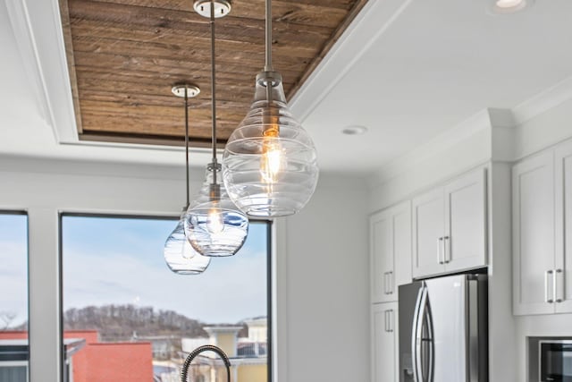 interior details with white cabinets, crown molding, and freestanding refrigerator