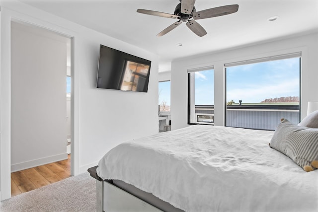 bedroom with baseboards, wood finished floors, a ceiling fan, and access to exterior