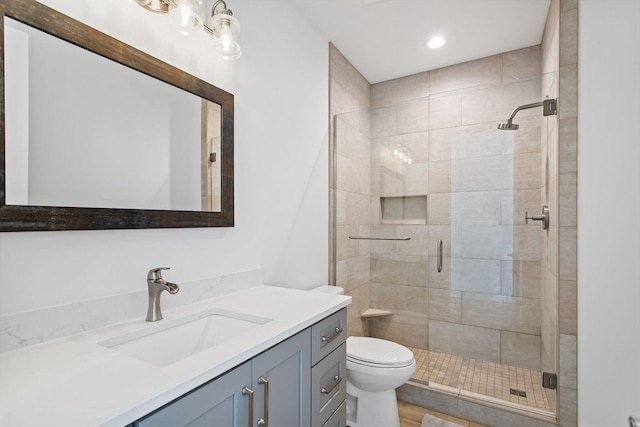 bathroom with vanity, toilet, and a shower stall