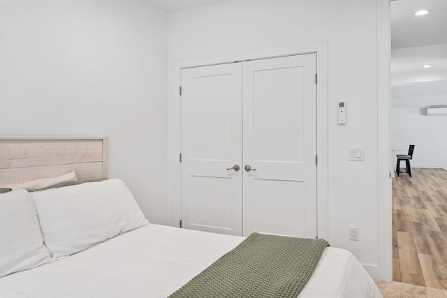 bedroom featuring recessed lighting, a closet, baseboards, and wood finished floors