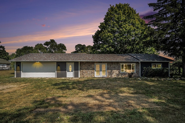 ranch-style house with a front lawn, a garage, french doors, and stone siding