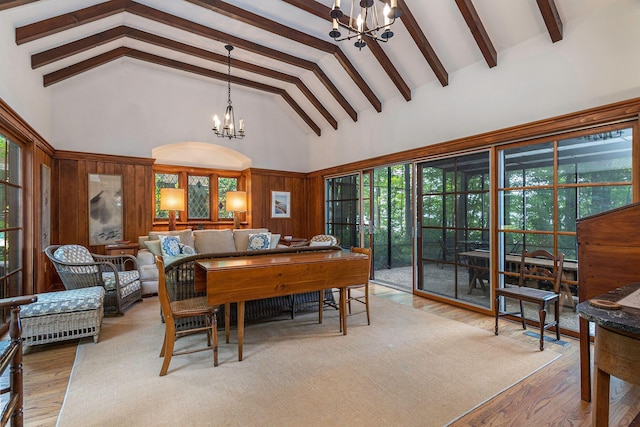 dining room with beamed ceiling, wood finished floors, high vaulted ceiling, and a chandelier