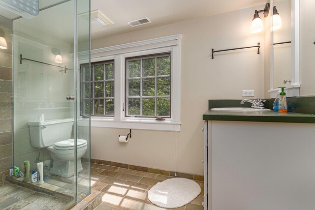 14598 Lakeshore Rd, Lakeside, MI 49116 - bathroom featuring visible vents, toilet, baseboards, tiled shower, and vanity