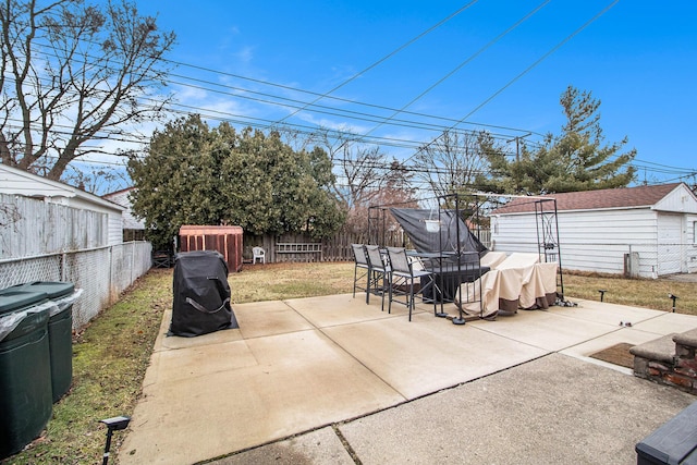 view of patio / terrace with outdoor dining space, an outdoor structure, and a fenced backyard