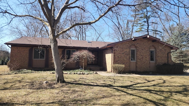 ranch-style home featuring a front lawn and brick siding