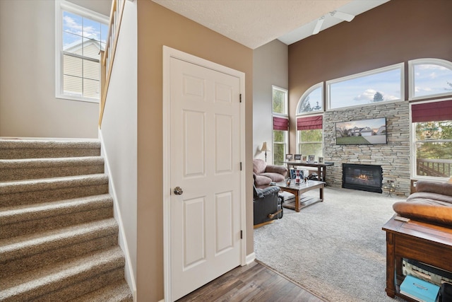 staircase featuring a wealth of natural light, baseboards, wood finished floors, and a fireplace