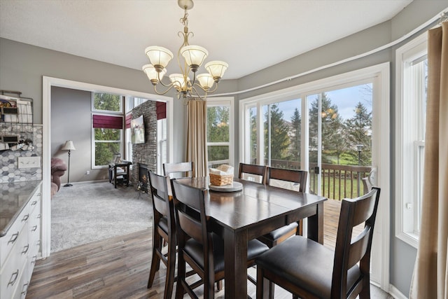 dining room with baseboards, a notable chandelier, dark wood finished floors, and dark carpet